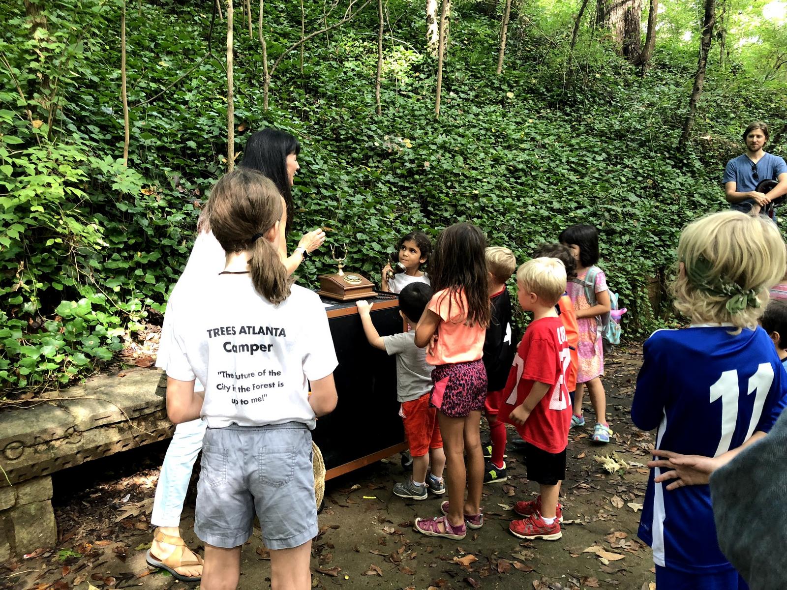 Chilren gather around a telephone installation that connected visitors to an underground spring.